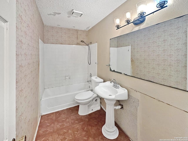 bathroom with bathtub / shower combination, parquet floors, a textured ceiling, and toilet