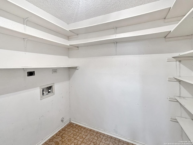 clothes washing area featuring hookup for a washing machine, hookup for an electric dryer, and a textured ceiling