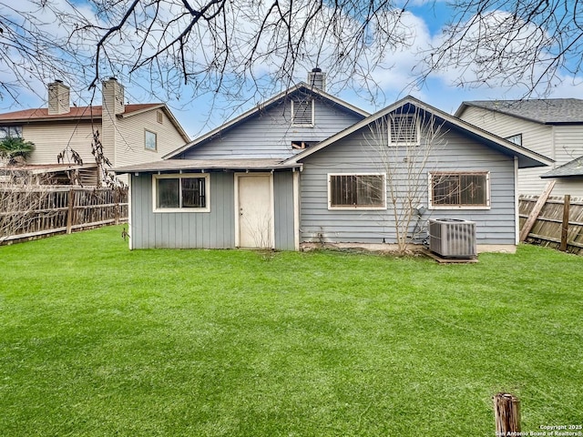 back of property featuring a lawn and central air condition unit