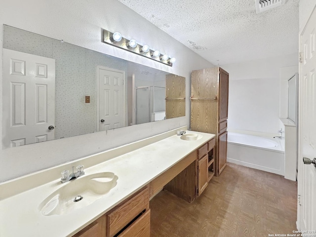 bathroom featuring vanity, shower with separate bathtub, and a textured ceiling