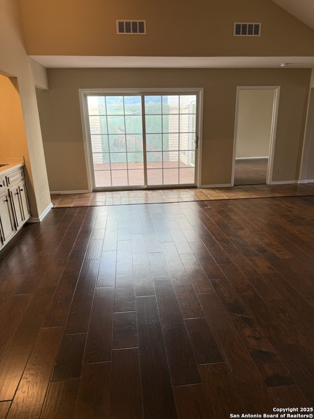 unfurnished living room with high vaulted ceiling and dark hardwood / wood-style floors