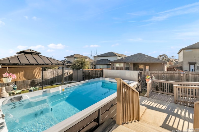 view of pool featuring a fenced backyard, a wooden deck, and a gazebo