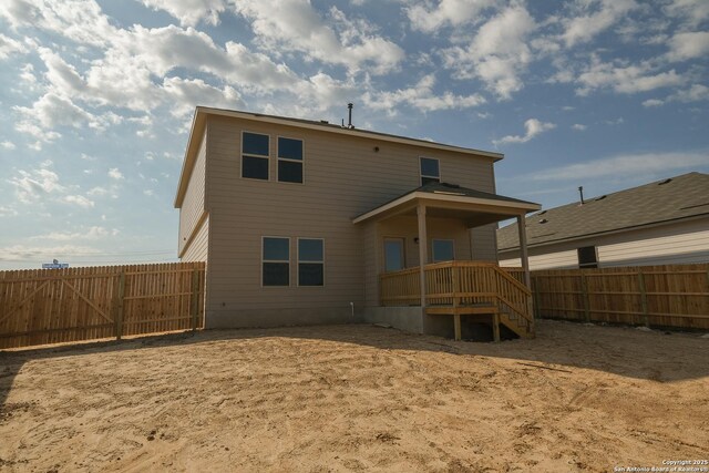 back of house with a fenced backyard