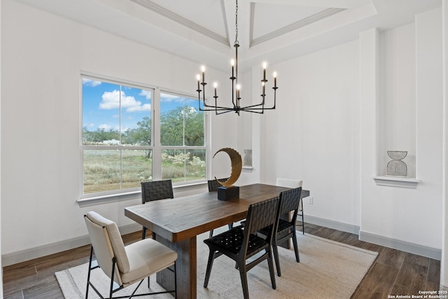 dining space with a raised ceiling, crown molding, and dark wood-type flooring