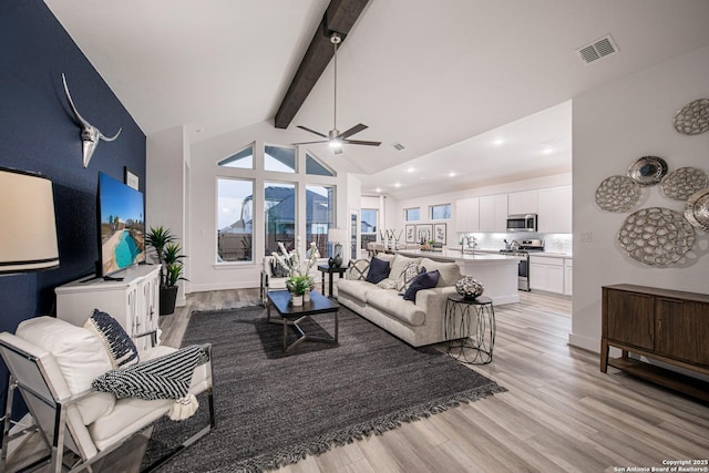 living room featuring vaulted ceiling with beams, ceiling fan, and light hardwood / wood-style flooring