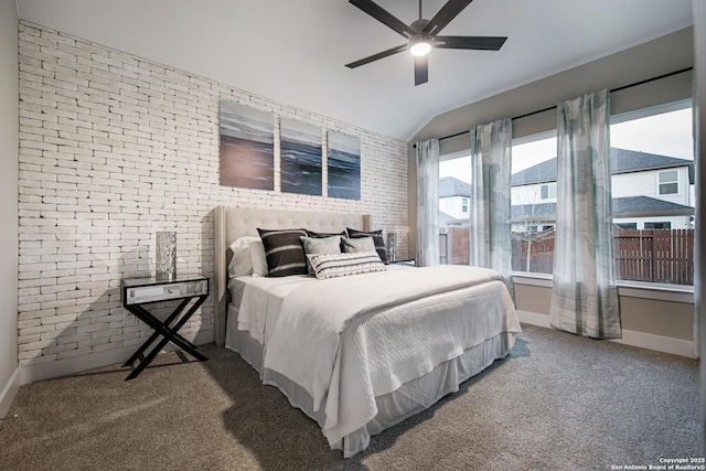 carpeted bedroom featuring ceiling fan, brick wall, and vaulted ceiling