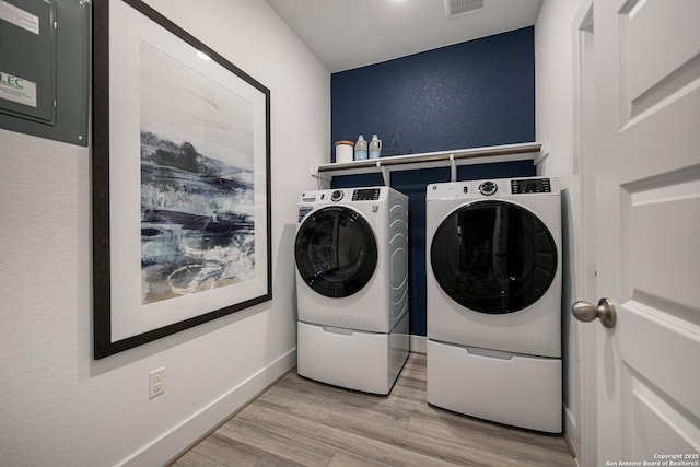 laundry room with washing machine and dryer and hardwood / wood-style flooring