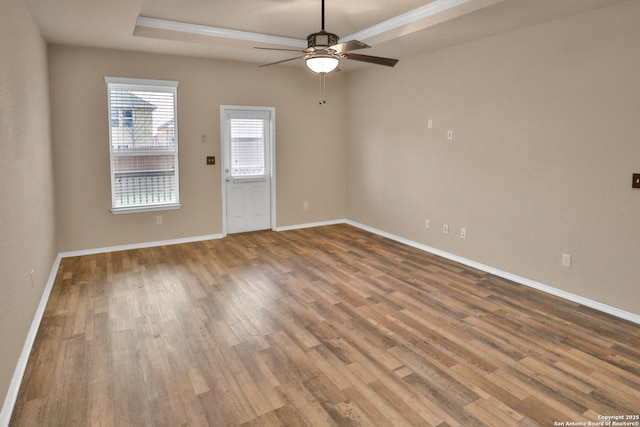 unfurnished room featuring a tray ceiling, ceiling fan, and wood-type flooring
