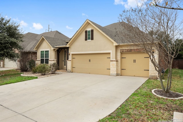 traditional home with a shingled roof, concrete driveway, an attached garage, fence, and stucco siding