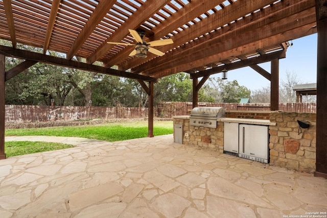 view of patio with a fenced backyard, an outdoor kitchen, a pergola, and grilling area