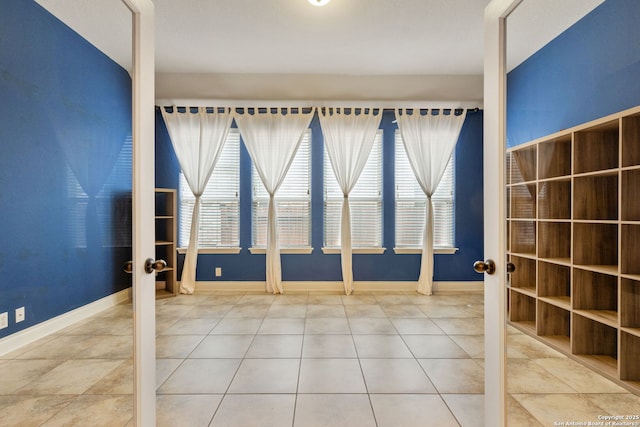 tiled spare room with french doors and baseboards