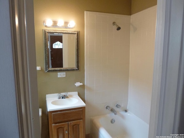 bathroom featuring tiled shower / bath combo and vanity