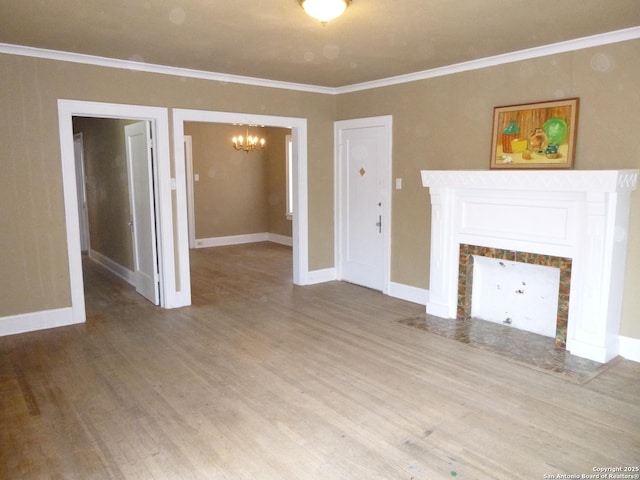 unfurnished living room with a tile fireplace, hardwood / wood-style floors, crown molding, and a chandelier