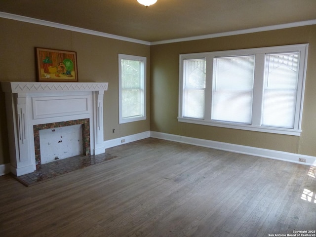 unfurnished living room featuring ornamental molding, a tiled fireplace, and hardwood / wood-style flooring