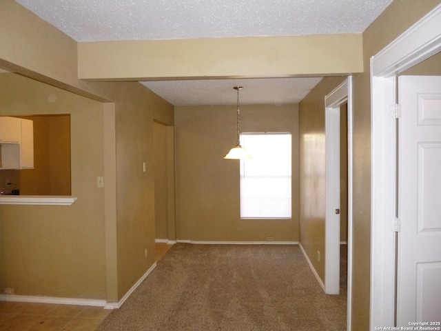 corridor with carpet flooring and a textured ceiling