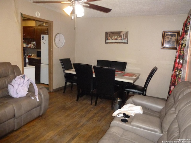 dining space with ceiling fan, dark wood-type flooring, and a textured ceiling