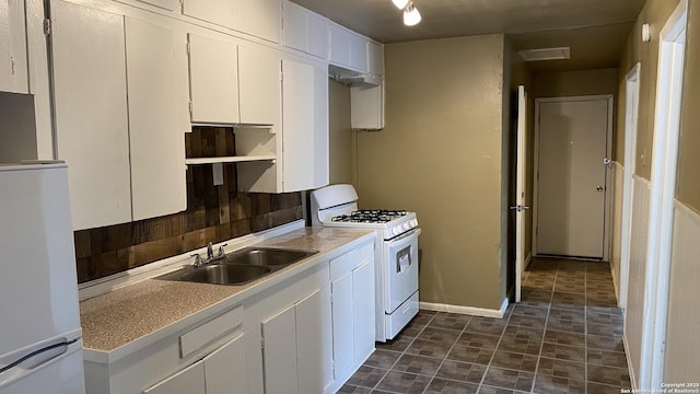 kitchen featuring white appliances, white cabinetry, and sink