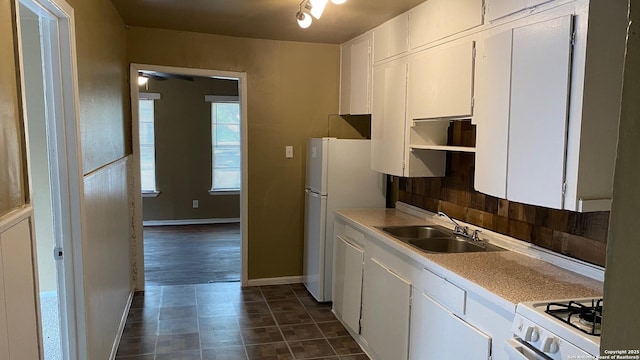 kitchen featuring sink, backsplash, white appliances, and white cabinets