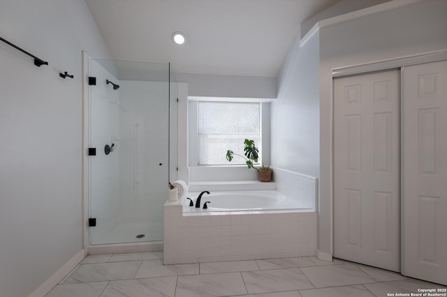 bathroom featuring lofted ceiling and independent shower and bath