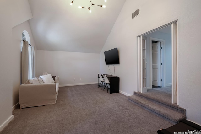 unfurnished living room with high vaulted ceiling, carpet, and a chandelier