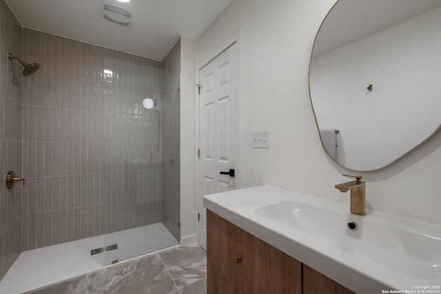 bathroom with vanity and a tile shower