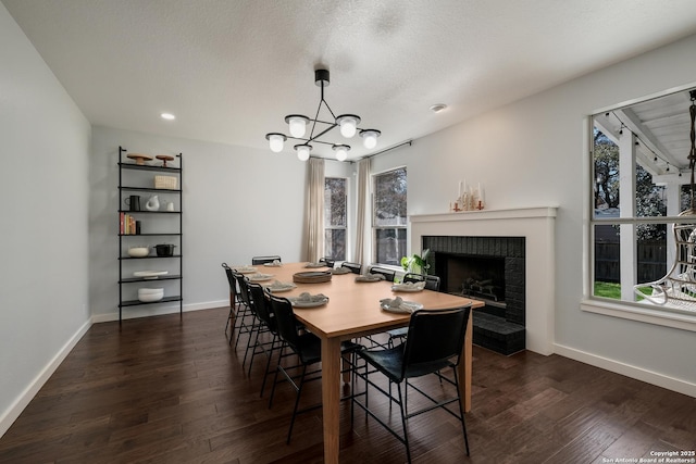 dining space with a brick fireplace, a healthy amount of sunlight, and dark hardwood / wood-style floors