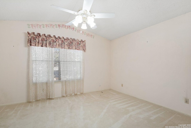 carpeted spare room featuring a ceiling fan