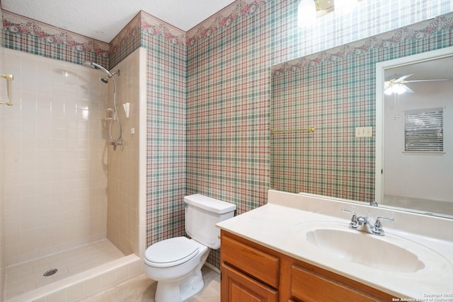 full bathroom with a textured ceiling, tiled shower, vanity, and toilet