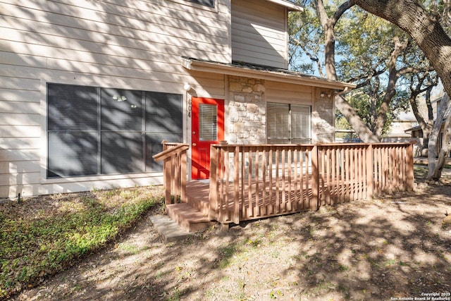 exterior space with stone siding and a deck