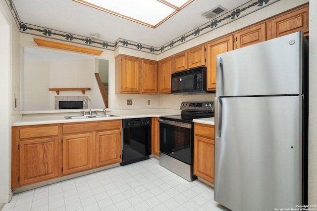 kitchen featuring black appliances, visible vents, light countertops, and a sink