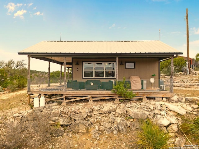 rear view of house featuring covered porch and metal roof