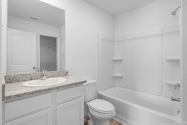 full bathroom with hardwood / wood-style floors, toilet, shower / washtub combination, and vanity