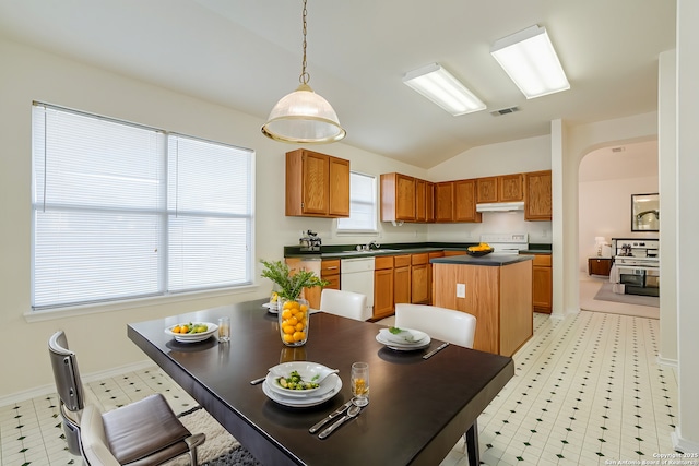 kitchen featuring lofted ceiling, range, a center island, white dishwasher, and pendant lighting