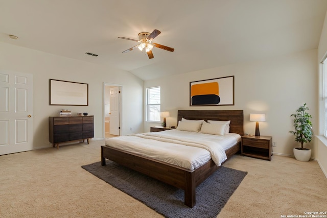 bedroom featuring connected bathroom, vaulted ceiling, ceiling fan, and light colored carpet