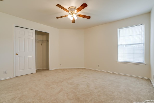 unfurnished bedroom featuring a closet, light colored carpet, and ceiling fan