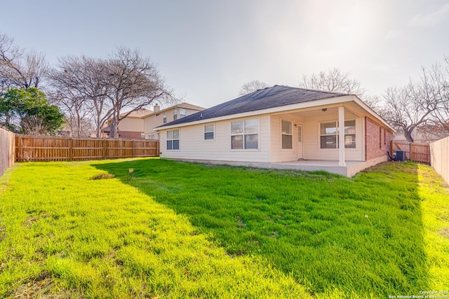 back of house featuring central air condition unit, a patio, and a lawn