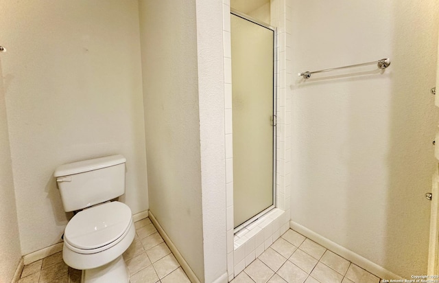 bathroom featuring toilet, tile patterned floors, and walk in shower