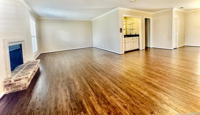 unfurnished living room with a brick fireplace, hardwood / wood-style floors, and ornamental molding