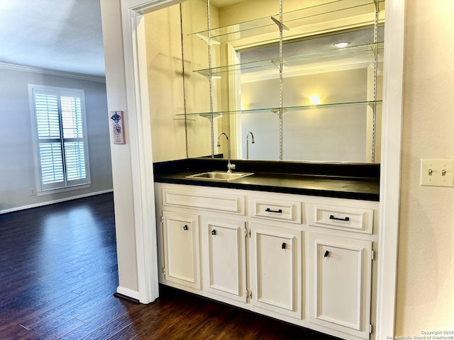 bar with crown molding, white cabinetry, sink, and dark hardwood / wood-style flooring