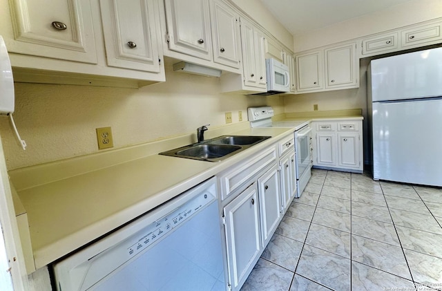 kitchen featuring white appliances, white cabinetry, and sink