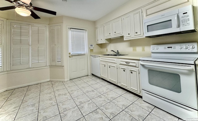 kitchen with white appliances, light tile patterned floors, sink, ceiling fan, and white cabinets