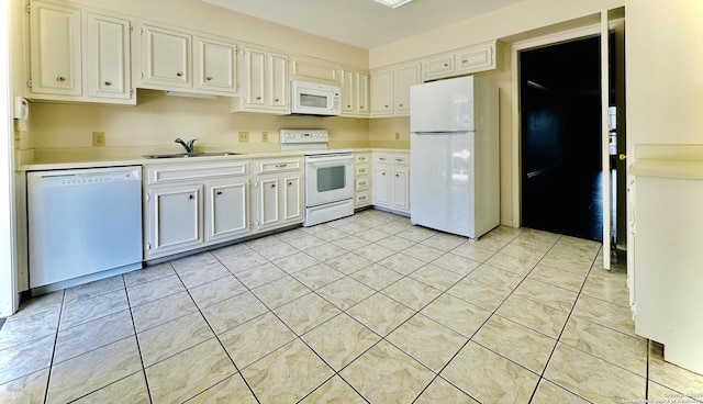 kitchen with sink, white appliances, white cabinets, and light tile patterned floors