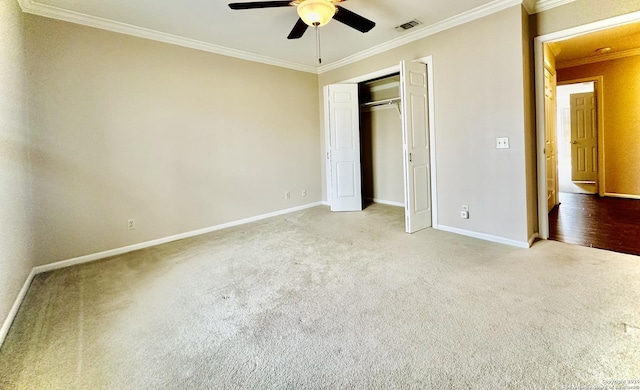 unfurnished bedroom with ceiling fan, carpet floors, crown molding, and a closet