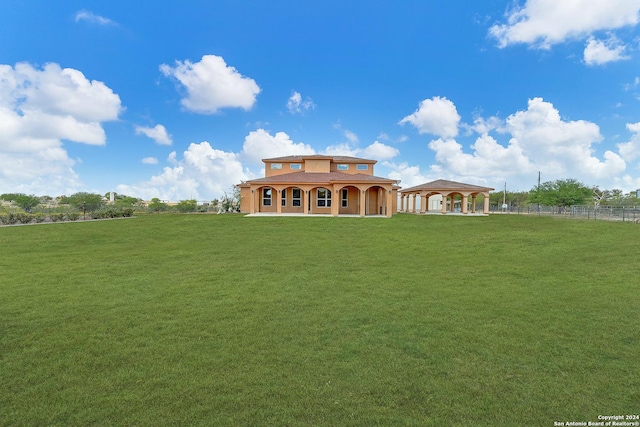 rear view of house with a yard and a gazebo