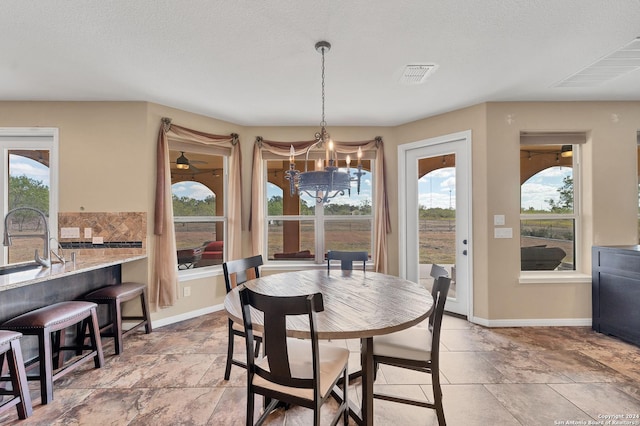 dining space featuring sink and a textured ceiling