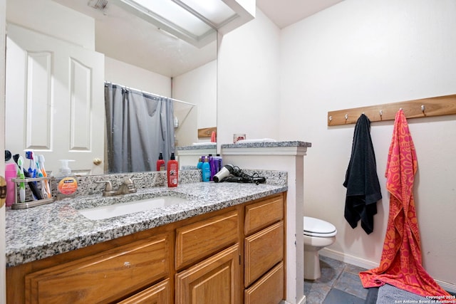 bathroom featuring toilet, vanity, and walk in shower