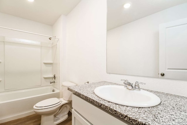 full bathroom featuring hardwood / wood-style flooring, toilet, bathing tub / shower combination, and vanity