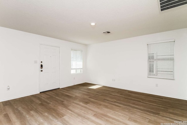 empty room featuring a textured ceiling and wood-type flooring