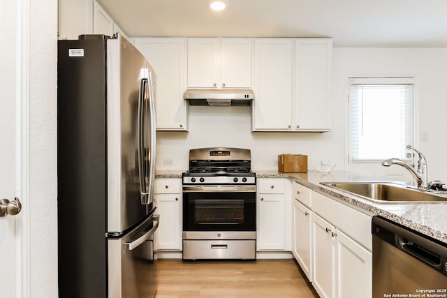 kitchen with light hardwood / wood-style flooring, sink, stainless steel appliances, white cabinets, and light stone countertops