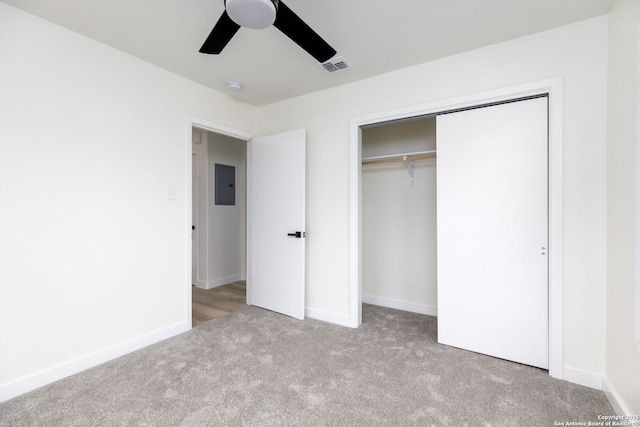 unfurnished bedroom featuring light carpet, electric panel, ceiling fan, and a closet